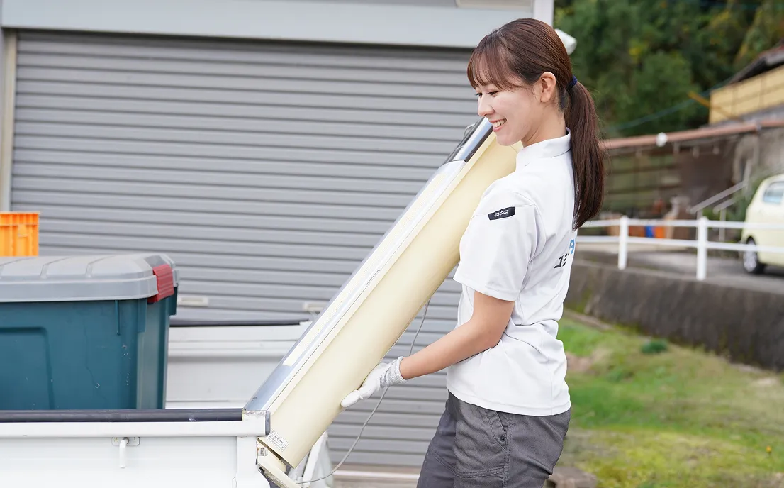 ゴミ屋敷タクセルの女性スタッフが片付けている画像