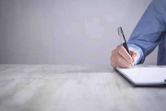 男性がメモをとっている画像