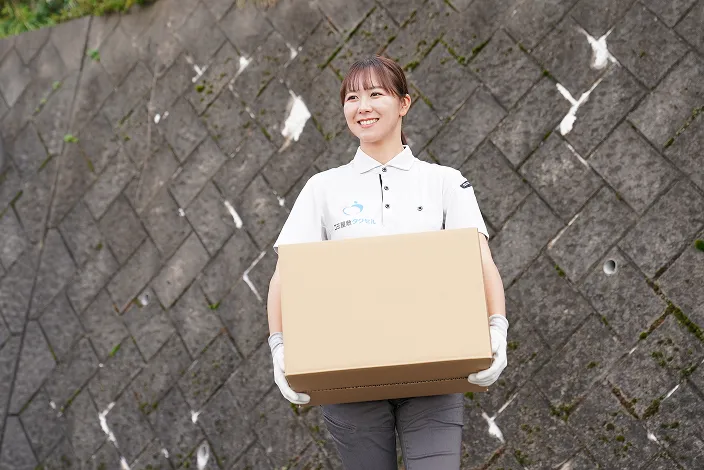 ゴミ屋敷タクセル東京の女性スタッフが箱を運んでいる画像